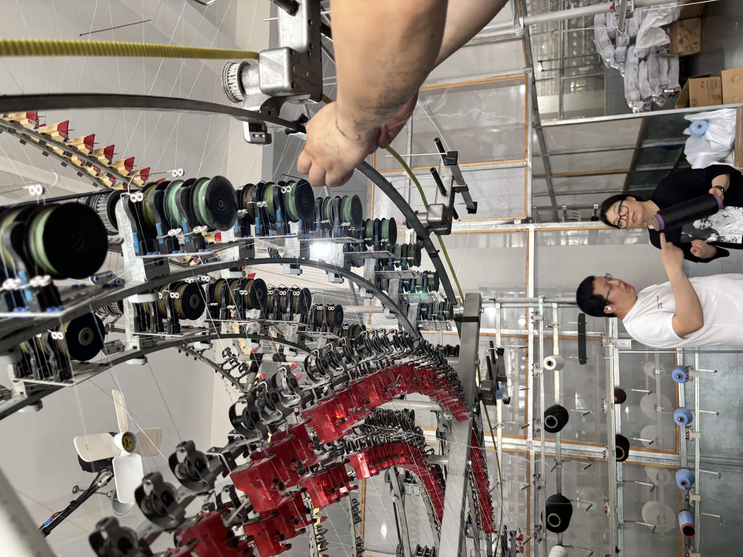 Worker changing yarn for knit fabric production